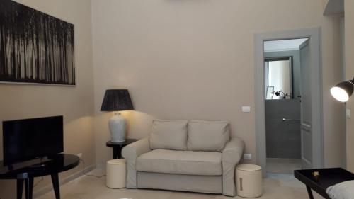a living room with a chair and a television at MammaDada charm rooms in Bari