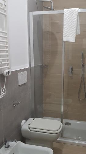 a bathroom with a toilet and a glass shower at MammaDada charm rooms in Bari