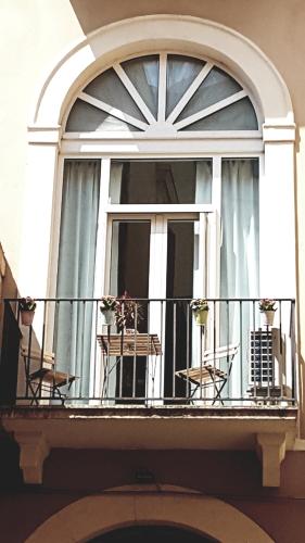 a balcony with tables and chairs on a window at MammaDada charm rooms in Bari