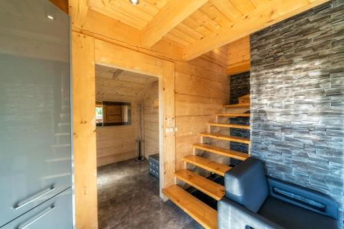 a wooden cabin with a staircase in a room with a brick wall at Domek w górach DeLuxe sauna,jacuzzi,basen,hot tub-Nowy Targ blisko Białka ,Zakopane in Nowy Targ