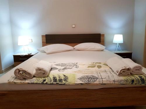 a bedroom with a bed with towels and two lamps at Mojo modern apartment 2 in Alikanas