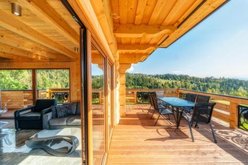 a view from the deck of a cabin with a table and chairs at Domek w górach DeLuxe sauna,jacuzzi,basen,hot tub-Nowy Targ blisko Białka ,Zakopane in Nowy Targ