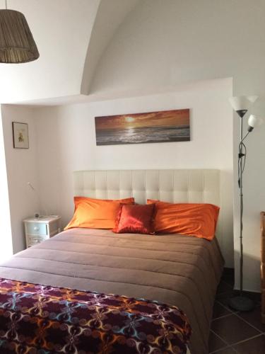 a bedroom with a large bed with orange pillows at SoleLuna House in Modica