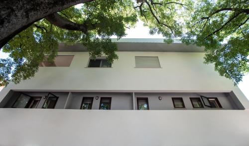 an external view of a white building with trees at Hotel Montereale in Pordenone