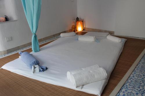 a large white bed in a room with a blue curtain at Itaca Home to Explorers in Polignano a mare in Polignano a Mare