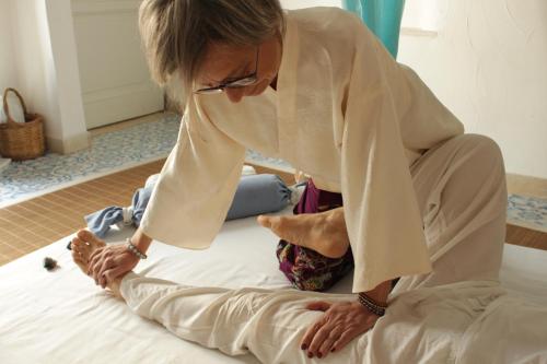 a woman sitting on a bed looking at her feet at Itaca Home to Explorers in Polignano a mare in Polignano a Mare