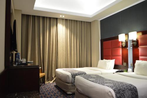 Een bed of bedden in een kamer bij Ramee Guestline Hotel
