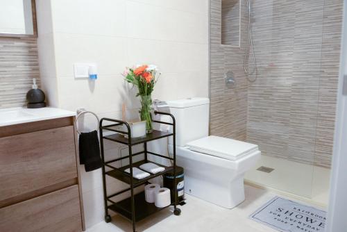 baño con aseo y jarrón de flores en Piso en La Ciudad de Artes, en Valencia