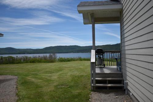 a porch of a house with a view of a lake at Seascape Coastal Retreat - 2 ADULTS ONLY - HOT TUB AND WITHOUT HOT TUB OCEANFRONT PROPERTY in Ingonish