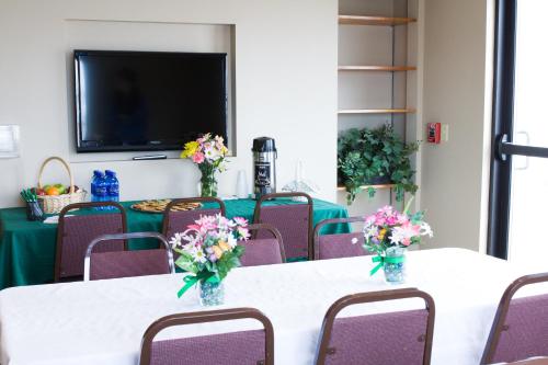 a conference room with a table with flowers on it at Baymont by Wyndham Sioux Falls North,I-29,Russell St, Airport in Sioux Falls