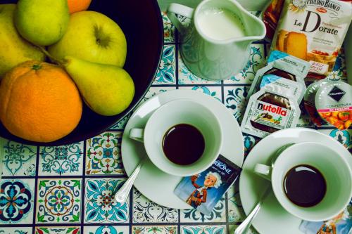 un tavolo con tazze di caffè e un cesto di frutta di La Gemma a Napoli