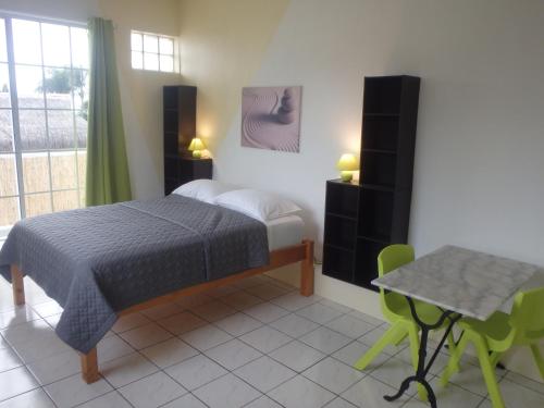 1 dormitorio con 1 cama, mesa y sillas en Apartment Studio Halfon, en Moorea