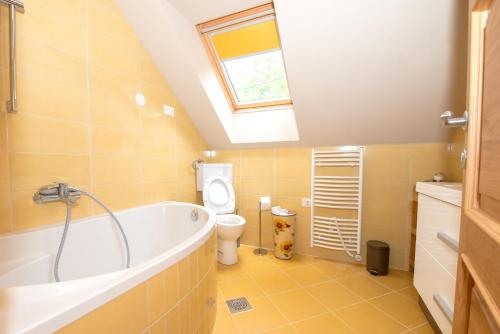 a bathroom with a tub and a toilet and a window at House Bovecation in Bovec