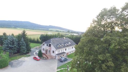 een luchtzicht op een groot huis met auto's geparkeerd op een parkeerplaats bij U nových přátel in Lichkov