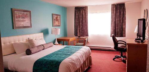 um quarto de hotel com uma cama e uma janela em Howard Johnson by Wyndham Fort St. John em Fort Saint John