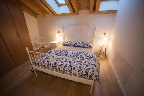 a bedroom with a white bed in a room with a window at La Tana dell'Orso Lavarone in Lavarone