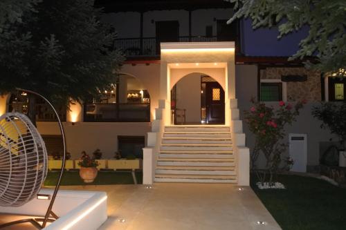 a house with a staircase in front of it at night at Hotel Konaki in Arnaia