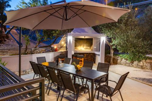 a table and chairs with an umbrella on a patio at Apartments Bella Figura in Makarska