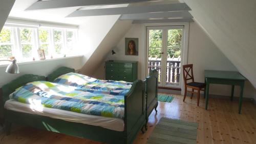 sypialnia z łóżkiem i biurkiem na poddaszu w obiekcie BILLE's HUS w mieście Tisvilde