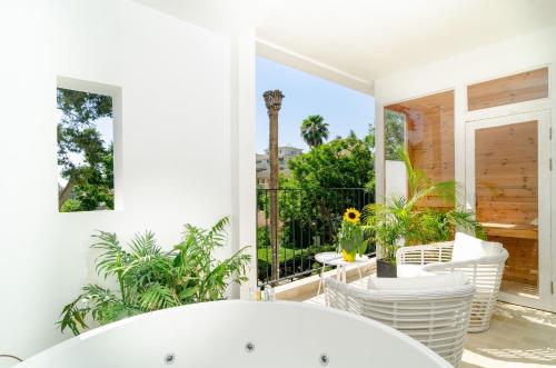 a white room with a balcony with a tub at Lear Sense Hotel in Gedera
