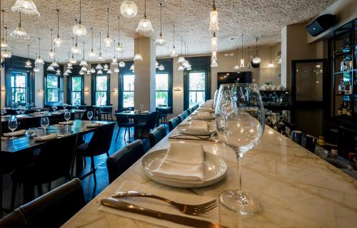 a long table in a restaurant with glasses on it at Lear Sense Hotel in Gedera