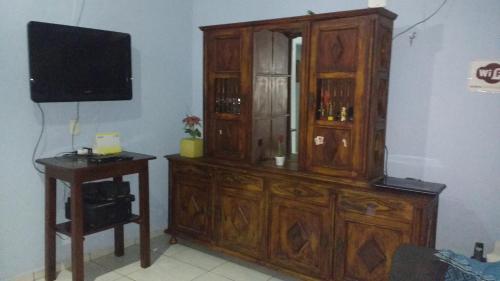 un gran armario de madera en una habitación con una mesa en Casa de Nylva Beach Pipa, en Pipa