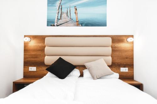 ein Schlafzimmer mit einem Bett und einem Bild eines Piers in der Unterkunft Hotel Castle Rastatt in Rastatt