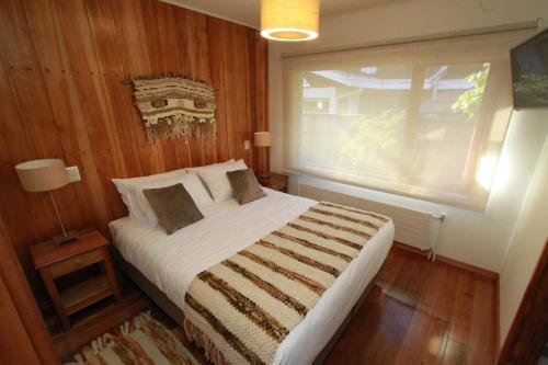 um quarto com uma cama grande e uma janela em Patagonia Route B&B em Puerto Varas