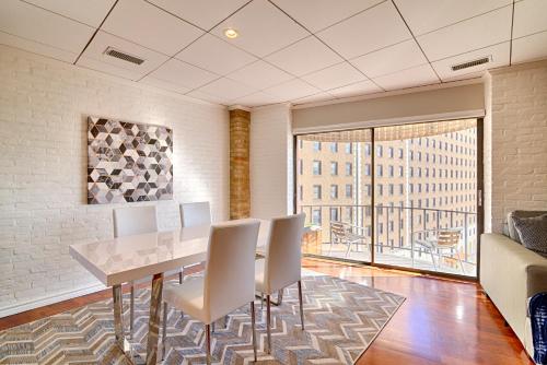 a dining room with a table and chairs and a large window at Riverwalk Plaza Hotel in San Antonio