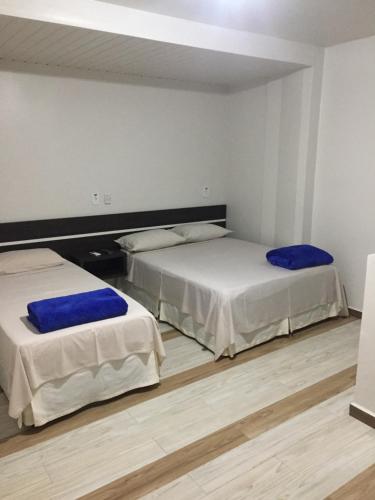 two beds sitting in a room with wood floors at Hotel Paradizzo in Foz do Iguaçu