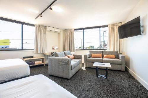 a hotel room with a bed couch and a tv at Nightcap at Chardons Corner Hotel in Brisbane