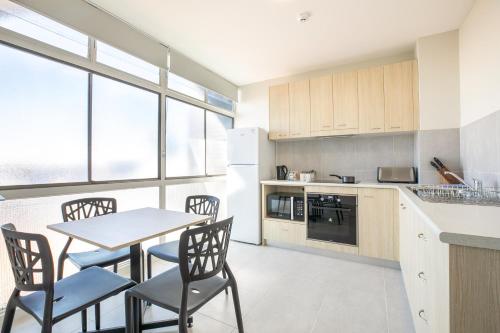 a kitchen with a table and chairs in a room at Nightcap at Chardons Corner Hotel in Brisbane