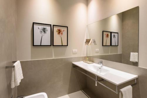 モンテヴァルキにあるPalazzo Vasarri - Luxury design suitesの洗面台と鏡のあるバスルーム