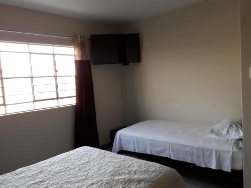 a hotel room with two beds and a window at Kira's House in Piura