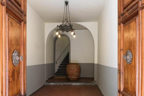a hallway with a stairway with a barrel and a chandelier at Palazzo Vasarri - Luxury design suites in Montevarchi
