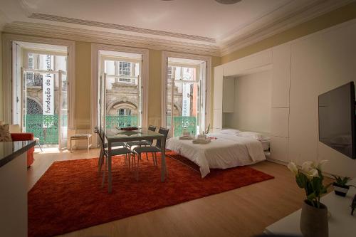 a bedroom with a bed and a table and chairs at São Domingos Flowers Apartments in Porto