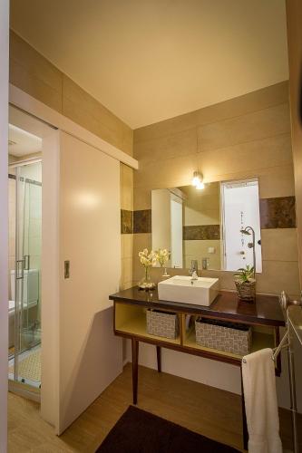 a bathroom with a sink and a mirror at São Domingos Flowers Apartments in Porto