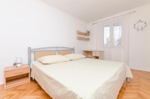 um quarto branco com uma cama e uma janela em Apartments Dasa em Primošten