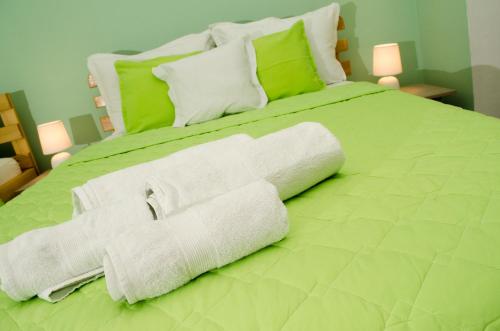 a large green bed with white towels on it at Villa Re3ca in Skopje