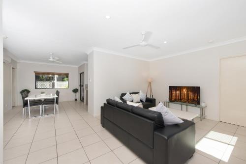 a living room with a couch and a fireplace at 3 bedroom central home in Townsville