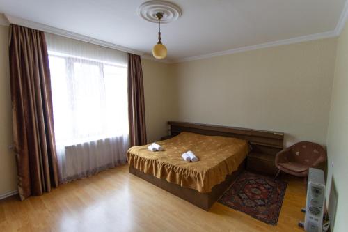 a bedroom with a bed and a large window at Eka&Nino GuestHouse in Mestia