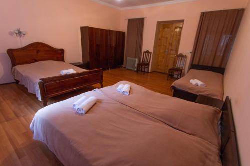 a hotel room with two beds with towels on them at Eka&Nino GuestHouse in Mestia