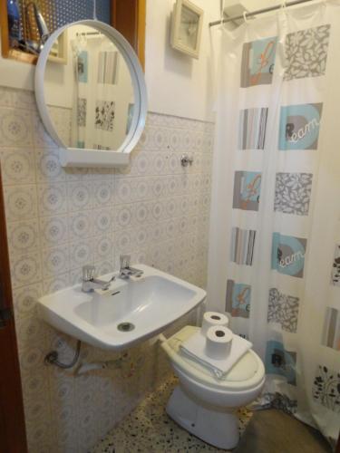 a bathroom with a sink and a toilet and a mirror at Oceanos in Costa da Caparica