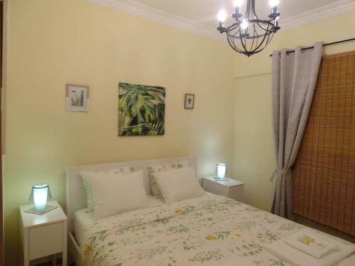 a bedroom with a bed and two night stands with lights at Oceanos in Costa da Caparica