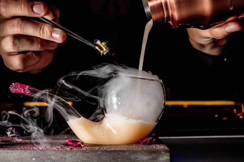 a person is mixing a drink in a bowl at InterContinental Hanoi Landmark72 by IHG in Hanoi