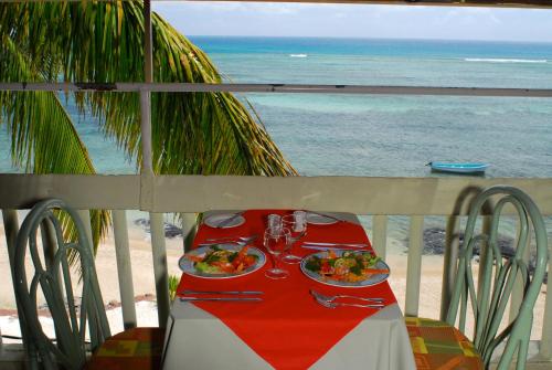 a table with two plates of food on the beach at Le Recif Hotel Rodrigues in Rodrigues Island