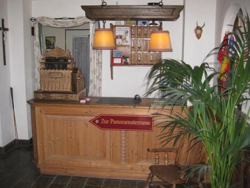 a room with a desk with a sign on it at Panoramahotel Karwendelhof in Wallgau