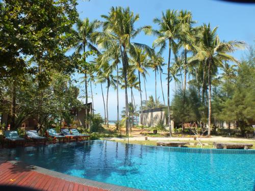a swimming pool with palm trees in the background at Pleasant View Resort in Ngapali