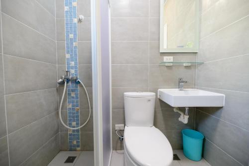 a bathroom with a toilet and a sink at 夏海民宿 in Magong
