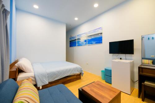 a bedroom with a bed and a flat screen tv at 夏海民宿 in Magong
